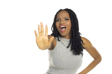 Siyah bir kadının beyaz arka planda çekilmiş bir fotoğrafı. Reddettiğini ya da uyardığını gösteriyor. El kaldırarak dur işareti yapıyor ve ağzını açıyor..