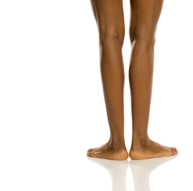 Çıplak siyah kadın bacakları, doğal cilt, beyaz arka planda stüdyo çekimi.