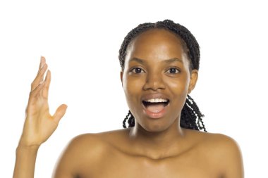Siyah kadın ağzı açık, eli havada, beyaz arka planda stüdyo çekimleriyle şaşırmış görünüyor.