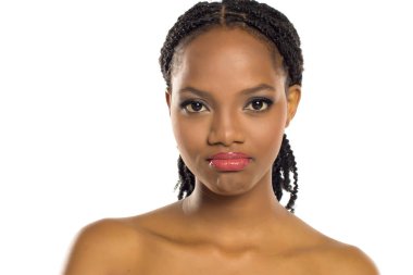 Üzgün ve tatminsiz bir ifadeyle siyah bir kadının portresi, beyaz arka planda stüdyo çekimi