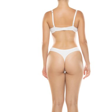 Beyaz iç çamaşırlı kadının dikiz aynası, beyaz arka planda stüdyo çekimi.