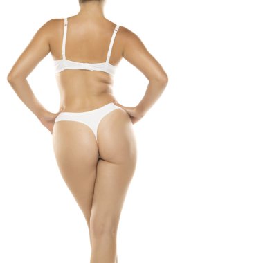 Beyaz iç çamaşırlı, elleri kalçasında, stüdyo resmi beyaz arka planda bir kadın.