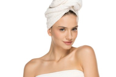 Havlu sarılı gülümseyen genç bir kadın güzellik tedaviden sonra poz veriyor..