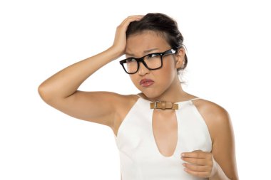 Gözlüklü Kazak kadın kafasına ağrı ya da şaşkınlık içinde dokunuyor, beyaz arka planda stüdyo çekimi yapıyor.