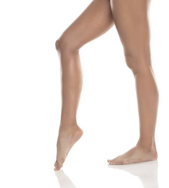 Kadın bacakları ve ayakları parmak uçlarında, pürüzsüz cilt ve hareketli zarafet, beyaz arkaplan