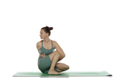 Beyaz arka planda yoga yapan, omurga bükme tekniği uygulayan bir kadının stüdyo fotoğrafı.