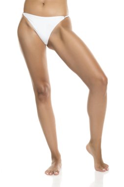 Beyaz bikinili, parmak uçlarında duran, beyaz arka planda ön görünümü olan kadınların stüdyo fotoğrafları.