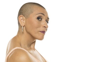 Bald woman with skeptical facial expression looking sideways, concept for attitude, body language, opinion, lifestyle, editorial, emotional communication