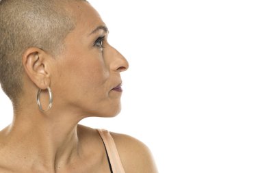 Profile portrait of a woman with a shaved head looking to the side, expressing focus, contemplation, or awareness.