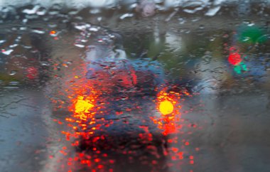 Yağmur damlaları sokak trafik ışıkları arka plan bulanık bir araba penceresindeki 