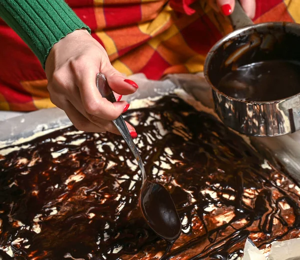 自宅でケーキにチョコレートガナッシュを入れてください 女性の手 — ストック写真