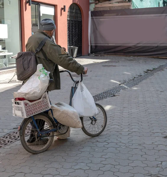 街の通りに古い自転車を持つ貧しい男 — ストック写真