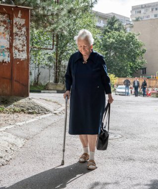 Yalta, Kırım - 22 Eylül 2013: Yalta 'da güneşli bir günde bastonlu yaşlı kadın sokakta yürüyor