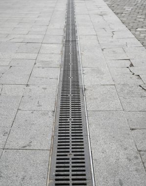 Yağmur yağdıktan sonra şehir merkezindeki kaldırım taşı caddesindeki drenaj kanalı temiz bir şehir manzarası yaratır.