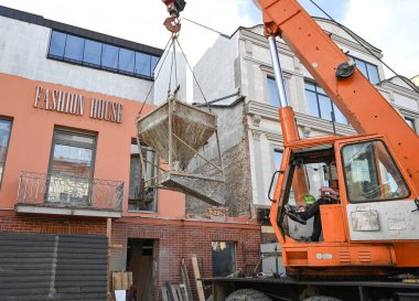 Uzhhorod, Ukrayna - 07 Mart 2025: İnşaat işçileri, Uzhhorod 'daki Petefi Meydanı' nda otel yenileme çalışmaları sırasında beton kaldırmak için vinç kullandılar
