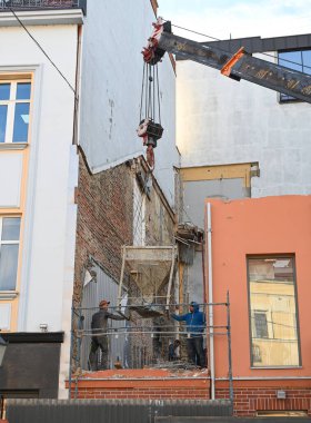 Uzhhorod, Ukrayna - 07 Mart 2025: İnşaat işçileri, Uzhhorod 'daki Petefi Meydanı' nda otel yenileme çalışmaları sırasında beton kaldırmak için vinç kullandılar