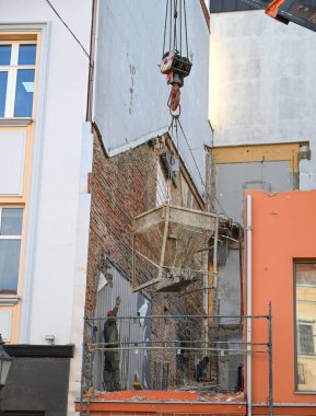 Uzhhorod, Ukrayna - 07 Mart 2025: İnşaat işçileri, Uzhhorod 'daki Petefi Meydanı' nda otel yenileme çalışmaları sırasında beton kaldırmak için vinç kullandılar