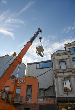 Uzhhorod, Ukrayna - 07 Mart 2025: Uzhhorod 'da Petefi Meydanı' nda yenilenmekte olan bir otelin üst katlarına Crane 'in inşaat malzemeleri taşınması