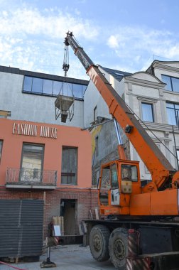 Uzhhorod, Ukrayna - 07 Mart 2025: Uzhhorod 'da Petefi Meydanı' nda yenilenmekte olan bir otelin üst katlarına Crane 'in inşaat malzemeleri taşınması