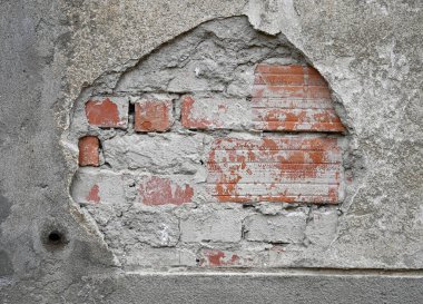 Yıpranmış duvar vitrinlerinin bir parçası harç parçalarının yanında tuğlaları da açığa çıkarıyor. Yüzey gölgelerinin dokusu ve yaşı kentsel bozulmayı yansıtıyor.
