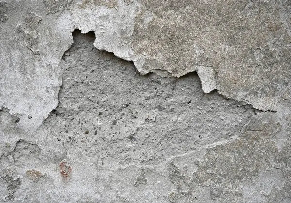 Eski bir beton duvarın altında kabuk soyma katmanlarının pürüzlü, desenli bir yüzeyi ortaya çıkardığı aşınmış. Renk geçişleri zaman içinde yaş ve hava durumu etkilerini vurgular