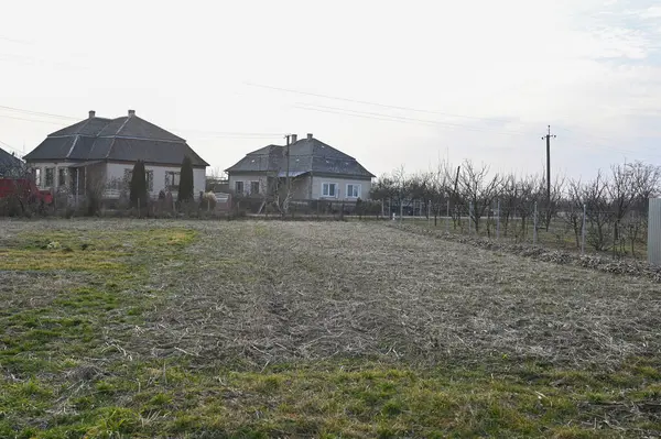 Boş arazili kırsal alan ve öğleden sonra saatlerinde sessiz bir ortamda evler. 