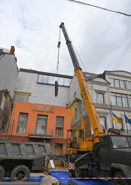 Uzhhorod, Ukrayna - 14 Mart 2025: Uzhhorod 'da bir otelin yeniden inşası sırasında bir inşaat alanında ağır ekipman taşıyan büyük vinç