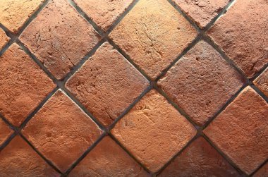 Elmas desenli terracotta fayanslarının yakın görüntüsü zengin toprak tonlarını ve desenli yüzeylerini vurguluyor, genellikle kırsal tasarımlarda kullanılır.