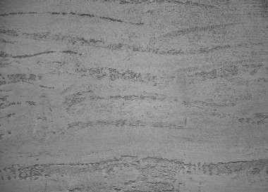 Dokulu beton duvar pürüzsüz ve pürüzsüz desenlere sahip, endüstriyel bir görünüm yaratıyor. Işık yüzeyde oynar, benzersiz detaylarını vurgular 