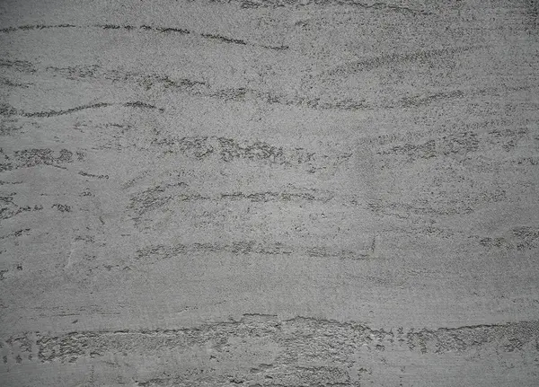 Dokulu beton duvar pürüzsüz ve pürüzsüz desenlere sahip, endüstriyel bir görünüm yaratıyor. Işık yüzeyde oynar, benzersiz detaylarını vurgular 