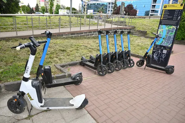 Uzhhorod, Ukrayna - 12 Mayıs 2025: Bir şehir parkının yakınına düzgün park edilmiş yedi elektrikli scooter, Uzhhorod 'daki yerli ve turistler için elverişli bir ulaşım aracı sunuyor