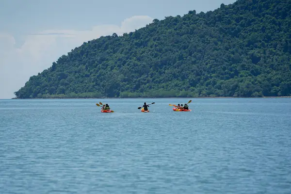 海と島を背景にツアーのための海の表面にカヌー旅行者のグループに選択的な焦点 — ストック写真