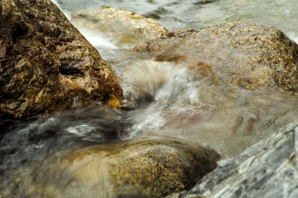Motion blurred of water flows on the stone in the stream. Low speed of shutter concept