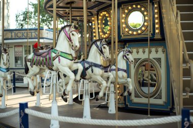 Motioned blurred picture of horse of the carousel with defocused horses and bokeh lights in background.