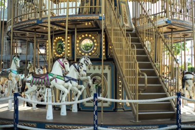 Motioned blurred picture of horse of the carousel with defocused horses and bokeh lights in background.