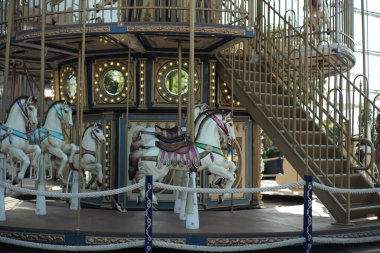 Motioned blurred picture of horse of the carousel with defocused horses and bokeh lights in background.