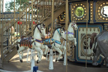 Motioned blurred picture of horse of the carousel with defocused horses and bokeh lights in background.