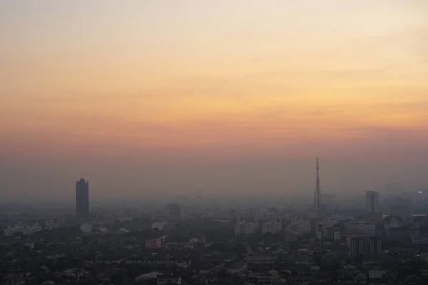 Shadow of the cityscape covered by dust and smoke with morning sky of sunrise in background