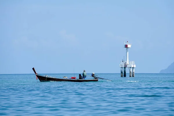 后视镜下的渔民与乘客驾驶着长尾船在大海中与分散的灯塔为背景 蓝天背景的海景天际 — 图库照片