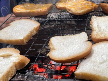 Kömür ızgarasında bir sürü dilimlenmiş ekmek.