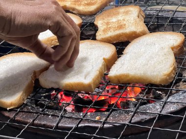 Kömür ızgarasında bir sürü dilimlenmiş ekmek.