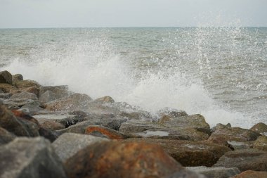 Güçlü dalga, deniz manzaralı kaya barajına çarpıyor.