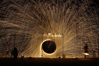 Geceleri sahilde yangın gösterisi. Gece şovunda parlayan ışığın yarıçapı