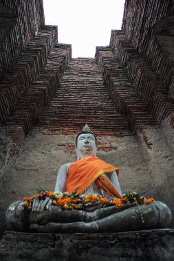 Yüksek açılı Buda heykeli arkaplanda yüksek kırmızı tuğla duvar