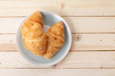 Ahşap arka planda kruvasan. Kopyalama alanı olan üst görünüm