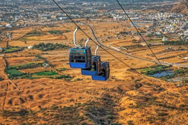 Hanging cabins of the ropeway to Savitri Mata temple on Ratnagiri hills in Pushkar India.