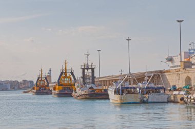 BARI, İtalya - 26 Eylül 2019 Güneşli bir günde limanda demirli balıkçı tekneleri ve römorkörler.