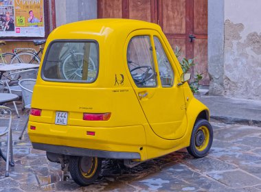 FLORENCE, ITALY - 25 Eylül 2019 Şehir merkezinin dar sokağında elektrikli araba Pasqali park etti.