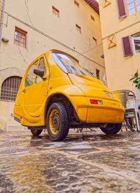 FLORENCE, ITALY - 25 Eylül 2019 Şehir merkezinin dar sokağında elektrikli araba Pasqali park etti.