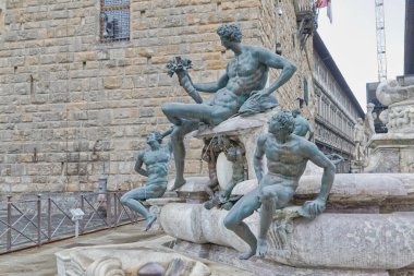 FLORENCE, ITALY - 25 Eylül 2019 Bronz bir adam heykeli, Piazza della Signoria 'daki Neptün Çeşmesi' nin detayları, Palazzo Vecchio 'nun önünde..